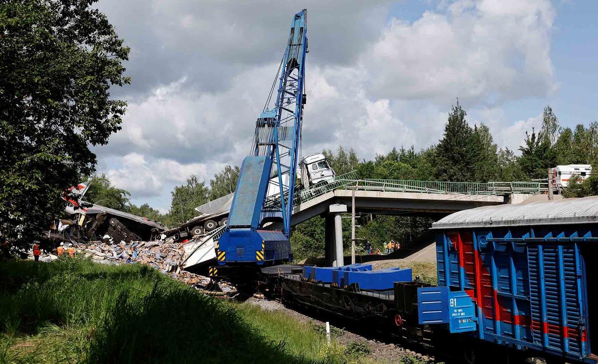 FOTO: Penampakan Gerbong Kereta Api Hancur Tertimpa Material Robohnya Jembatan Jalan Raya di Rusia