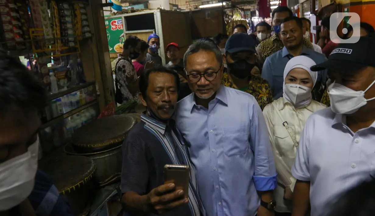 Menteri Perdagangan Zulkifli Hasan (tengah) berfoto dengan warga saat meninjau harga bahan pokok di Pasar Cibubur, Jakarta, Kamis (16/6/2022). Kunjungan tersebut dilakukan untuk melihat dan memantau langsung harga bahan pokok guna memastikan harga stabil menjelang Hari Raya Idul Adha 1443 Hijriah. (Liputan6.com/Herman Zakharia)
