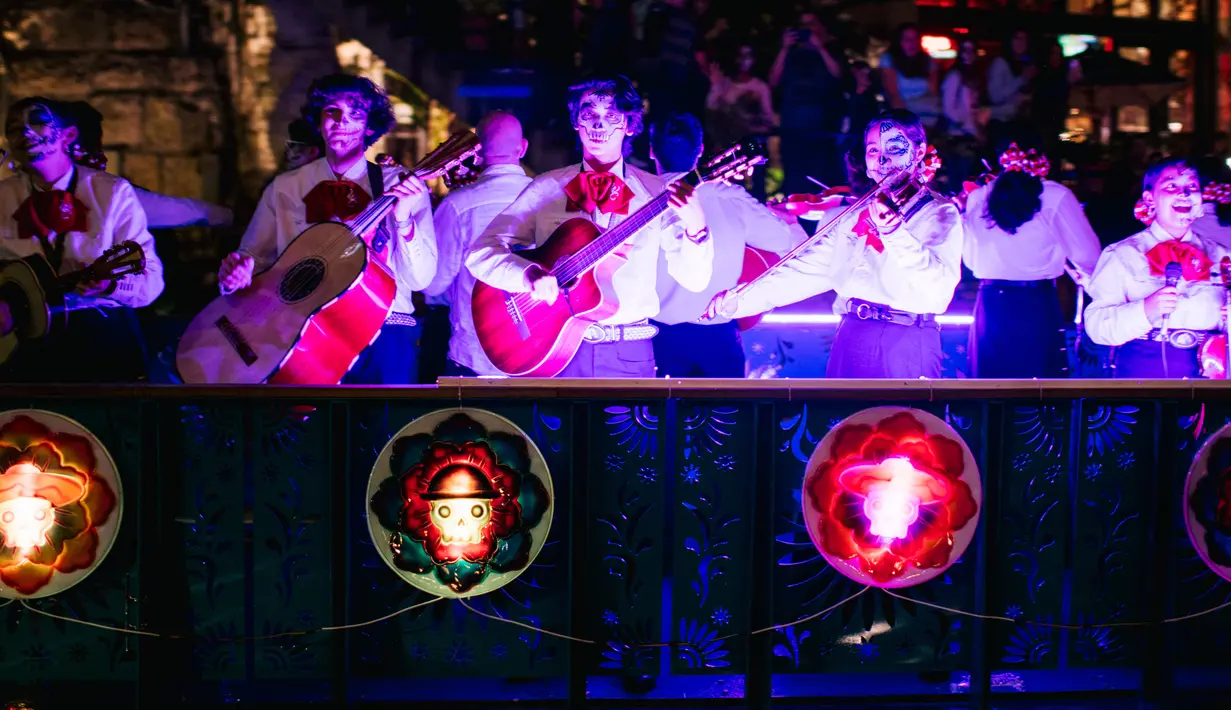 Band Mariachi bermain di kendaraan hias selama parade Hari Sungai Mati di San Antonio, Texas, Amerika Serikat, 29 Oktober 2021. Warga berkumpul untuk merayakan, memperingati, dan mengenang orang-orang terkasih yang telah meninggal untuk Día de los Muertos tahun ini. (Brandon Bell/Getty Images/AFP)