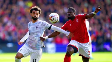 Pemain Liverpool Mohamed Salah (kiri) berebut bola dengan pemain Nottingham Forest Serge Aurier pada pertandingan sepak bola Liga Inggris di City Ground, Nottingham, Inggris, 22 Oktober 2022. Liverpool dikalahkan dengan skor 0-1. (Joe Giddens/PA via AP)