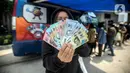 Warga menunjukkan uang rupiah kertas baru emisi 2022 saat penukaran di Pasar Senen, Jakarta, Selasa (23/8/2022). Bank Indonesia (BI) baru saja meluncurkan uang rupiah kertas baru emisi 2022 bersamaan dengan momen HUT ke-77 RI. (Liputan6.com/Faizal Fanani)