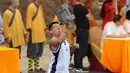 Seorang peserta pria mengangkat kunci batu dengan ujung tangannya pada kompetisi seni bela diri '72 Arts of Shaolin' di kuil Shaolin, Provinsi Henan, China, 30 Juli 2017. Kompetisi ini menampilkan para jago kungfu yang memamerkan kekuatan fisik. (STR AFP)