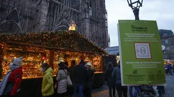 Pembeli yang mengenakan masker berjalan-jalan di pasar Natal di Strasbourg, Prancis, Jumat (26/11/2021). Prancis mengumumkan keputusan suntikan Booster Covid-19 untuk semua orang dewasa agar tak lagi menerapkan pembatasan wilayah, atau batasan jam malam. (AP Photo/Jean-Francois Badias)