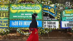 Pelayat melewati karangan bunga yang menghiasi jalan menuju rumah duka Presiden ke-3 RI BJ Habibie di Kuningan, Jakarta, Kamis (12/9/2019). Ucapan belasungkawa terus mengalir melalui karangan bunga dari berbagai elemen masyarakat. (Liputan6.com/Immanuel Antonius)