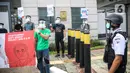 Massa mengenakan pelindung wajah dan masker saat menggelar aksi di depan Kedubes Korea Selatan di Jakarta, Kamis (25/6/2020). Dalam aksinya, mereka meminta Korsel membatalkan rencana pendanan untuk proyek PLTU Jawa 9 dan 10 di Banten yang dinilai merusak lingkungan. (Liputan6.com/Faizal Fanani)