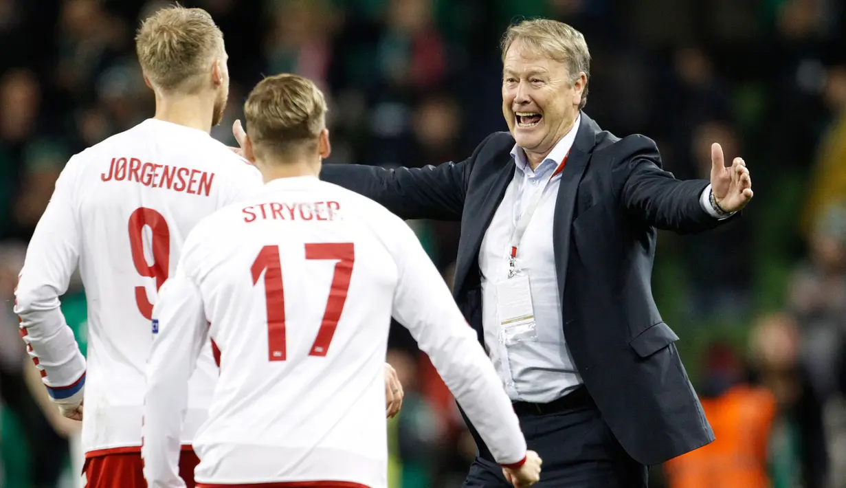 Pelatih timnas Denmark Age Hareide merayakan bersama timnya kemenangan atas Republik Irlandia pada partai kedua play-off zona Eropa di Stadion Aviva, Rabu (15/11). Denmark melaju ke putaran final Piala Dunia 2018 usai menang 5-1. (AP/Peter Morrison)