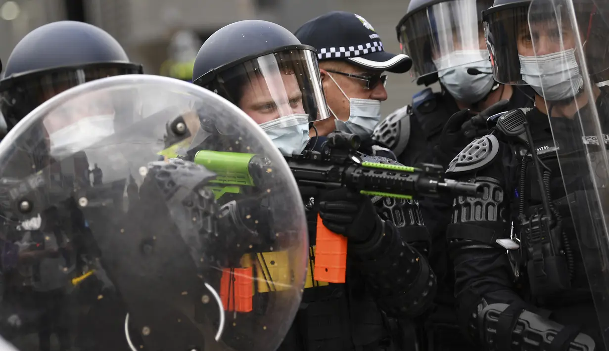 Polisi mengenakan pakaian anti huru hara selama protes anti-lockdown di Melbourne, Australia, Sabtu (21/8/2021). Para pengunjuk rasa berunjuk rasa menentang pembatasan pemerintah yang ditempatkan dalam upaya mengurangi wabah COVID-19. (James Ross/AAP Image via AP)