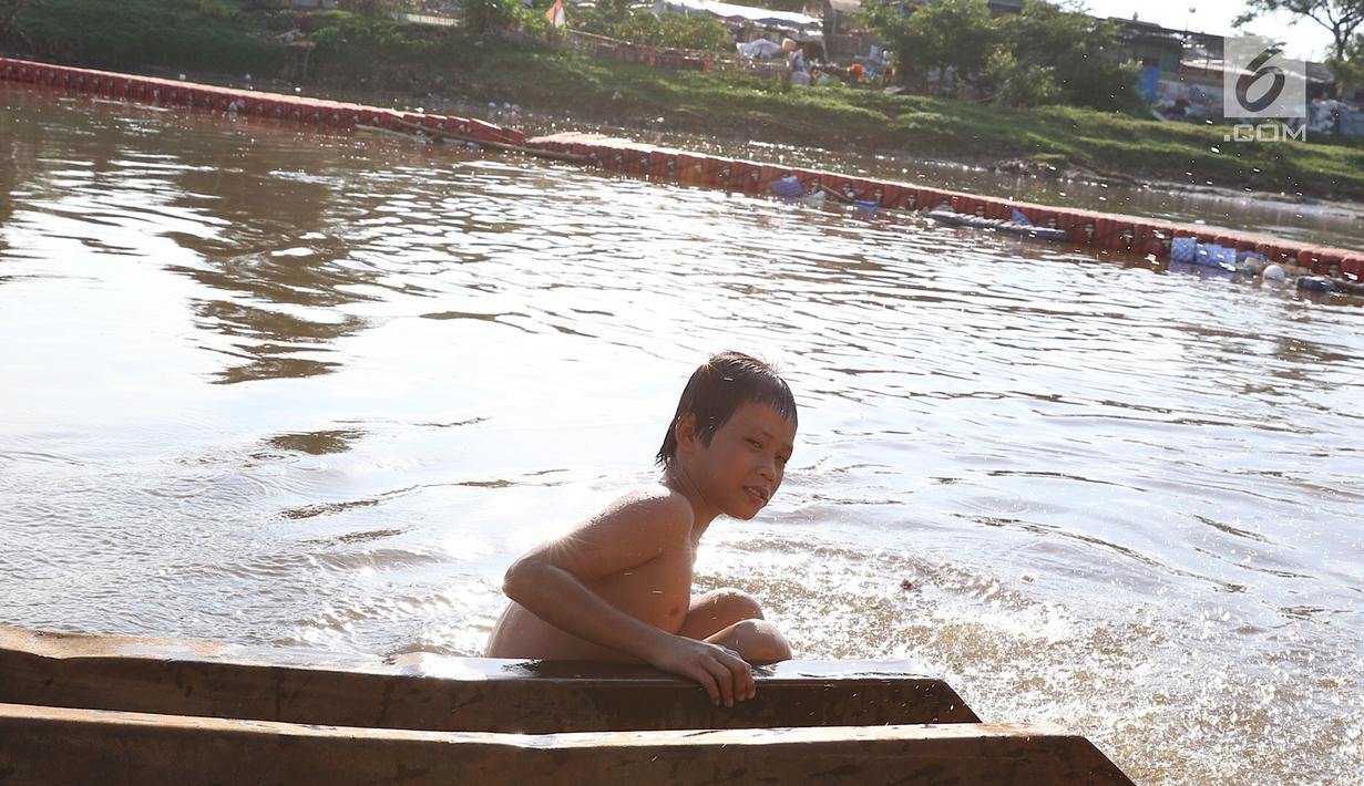 Seorang anak berenang di Kanal Banjir Barat, Jakarta, Jumat (23/3). Mahalnya biaya sewa kolam renang menyebabkan anak-anak berenang tidak pada tempatnya. (Liputan6.com/Immanuel Antonius)