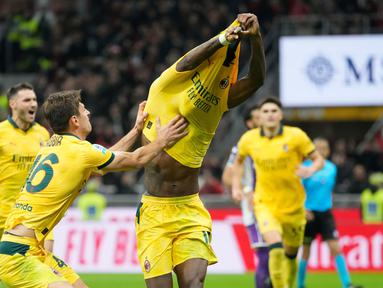 Pemain AC Milan, Matteo Gabbia, berusaha mencegah Rafael Leao melakukan selebrasi buka baju setelah mencetak gol ke gawang Fiorentina pada laga Liga Italia di Stadion San Siro. (AP Photo/Luca Bruno)