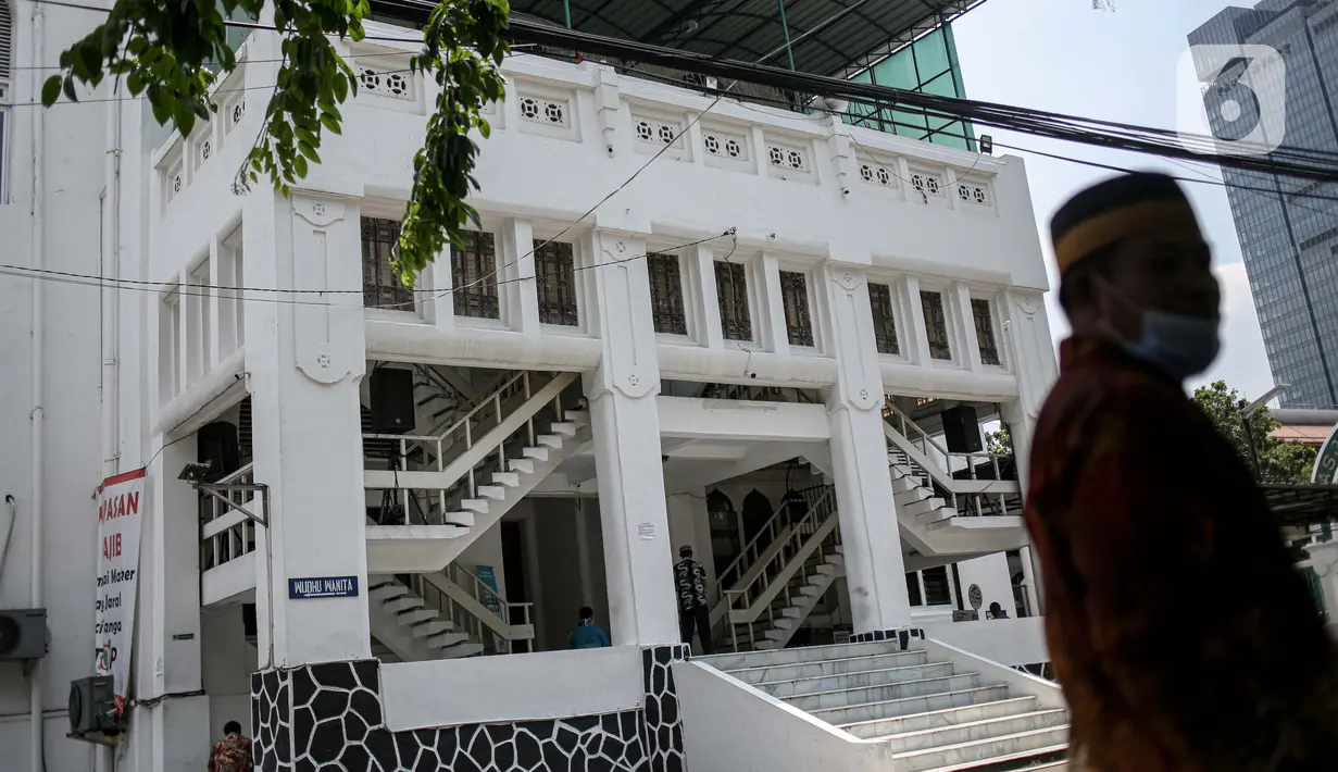Warga berjalan di halaman depan Masjid Cut Meutia, Jakarta, Jumat (18/9/2020). Pemprov DKI Jakarta kembali meniadakan kegiatan ibadah salat Jumat dan salat lima waktu berjemaah di semua Masjid Raya selama PSBB. (Liputan6.com/Faizal Fanani)