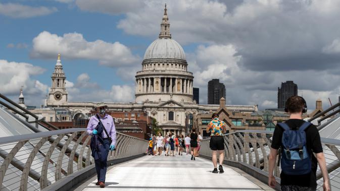 Orang-orang berjalan di Jembatan Milenium dengan latar pemandangan Katedral St. Paul di London, Inggris, 1 Agustus 2020. Pemerintah Inggris pada Jumat (31/7) mengumumkan penundaan pelonggaran beberapa langkah pembatasan menyusul jumlah infeksi virus corona yang meningkat. (Xinhua/Han Yan)