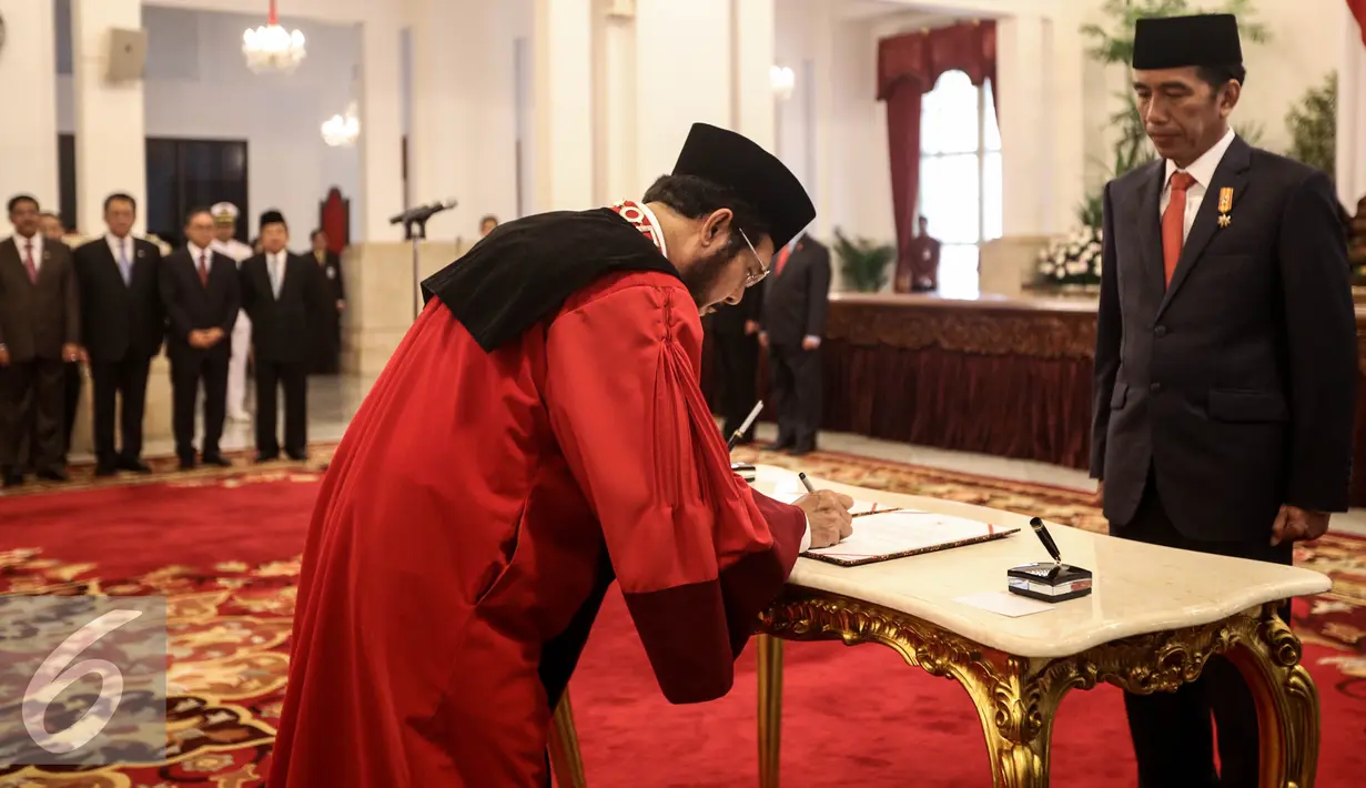 Wakil Ketua Mahkamah Konstitusi Anwar Usman menandatangani berita acara usai pengucapan sumpah sebagai Hakim Konstitusi didepan Presiden Joko Widodo di Istana Negara, Jakarta, Kamis (6/4). (Liputan6.com/Faizal Fanani)