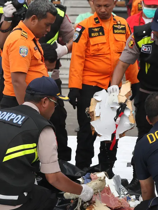 Petugas merapikan sejumlah barang temuan yang diduga serpihan pesawat Lion Air JT 610 di Pelabuhan JICT 2, Jakarta, Selasa (30/10). Sejumlah barang ditemukan petugas gabungan dalam operasi pencarian. (Liputan6.com/Helmi Fithriansyah)