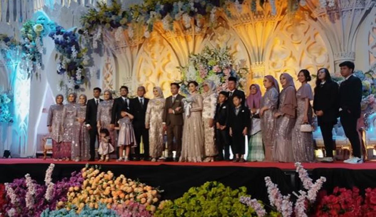 Perasaan haru bahagia terpancar di momen pernikahan adiknya, Sinta Mutiara. Dalam vlog-nya, terlihat suasana pernikahan sang adik yang digelar cukup mewah. Tak lupa di momen tersebut, mereka mengabadikan momen bersama foto keluarga besar. (Liputan6.com/YouTube/@Indah Permatasari)