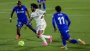 Pemain Real Madrid Marcelo (tengah) menggiring bola melewati pemain Getafe Alena (kanan) dan Allan Nyom (kiri) pada pertandingan Liga Spanyol di Stadion Alfonso Perez, Getafe, Spanyol, Minggu (18/42021). Pertandingan berakhir dengan skor 0-0. (AP Photo/Manu Fernandez)