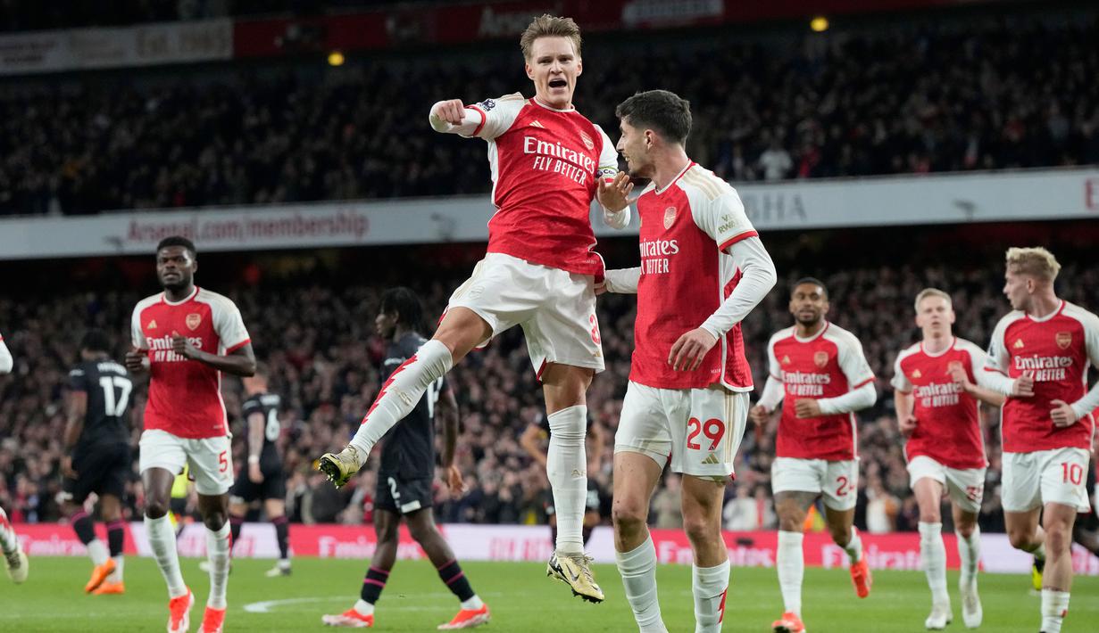 Pemain Arsenal Martin Odegaard melakukan selebrasi setelah mencetak gol pembuka timnya saat pertandingan sepak bola Liga Premier Inggris melawan Luton Town di Stadion Emirates, London, Rabu, 3 April 2024. (AP Photo/Frank Augstein)