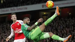 Pemain Arsenal, Mesut Ozil (kiri) melihat pemain Sunderland, Yann M'vila melakukan tendangan salto pada lanjutan Liga  Premier Inggris di Stadion Emirates, London, Sabtu (5/12/2015). (AFP Photo/Ikimages) 