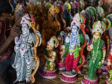 Seorang seniman India mewarnai patung dewa Hindu Rama di sebuah lokakarya di Hyderabad, India (15/3). Para seniman ini membuat patung dewa menjelang festival Rama Navami. (AFP/Noah Seelam)