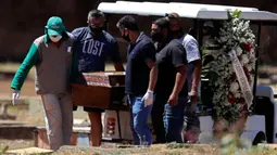 Petugas membawa peti jenazah berisi Elvira Maria de Jesus (75), yang dikatakan meninggal karena COVID-19, di pemakaman Campo da Esperanca di Brasilia, Brasil, Kamis (3//9/2020). Brasil melaporkan rata-rata lebih dari 1.000 kematian setiap hari akibat corona sejak akhir Mei. (AP Photo/Eraldo Peres)