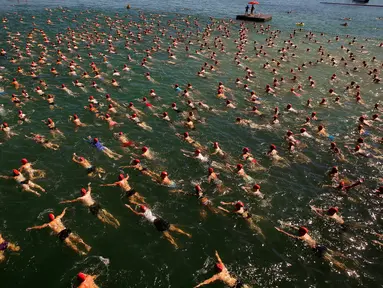 Para peserta saat mengikuti lomba berenang menyeberangi Danau Zurich, Swiss (24/8). Lomba sejauh 1,5 km ini diikuti oleh ratusan orang mulai dari anak muda hingga orang tua. (REUTERS/Arnd Wiegmann)