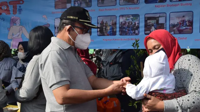 Bupati Banyumas Achmad Husein bercengkrama dengan balita yang menggemaskan, dalam Harganas. (Foto: Liputan6.com/Humas Pemkab Banyumas)