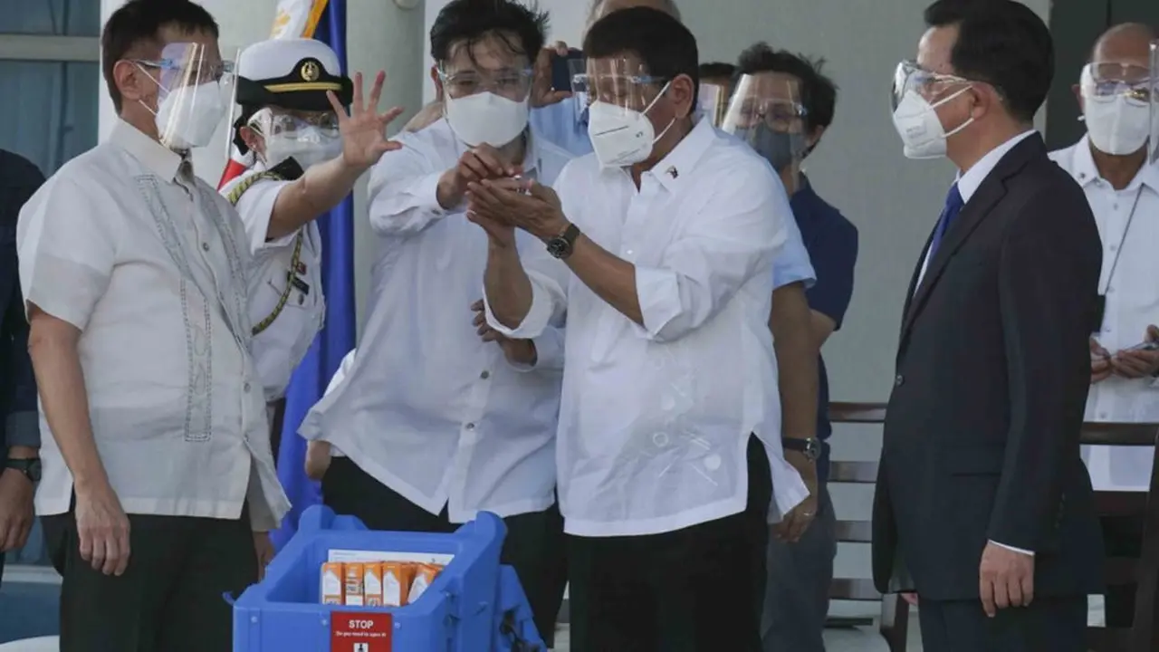 Presiden Rodrigo Duterte memegang vaksin COVID-19 Sinovac gelombang pertama yang tiba di negaranya, 28 Februari 2021 (AP Photo)
