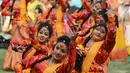 Sejumlah siswi menari selama perayaan Holi di Kolkata, India (7/3). Puncak perayaan Holi disebut Dhulheti, Dhulandi, atau Dhulendi. (AFP/Dibyangshu)