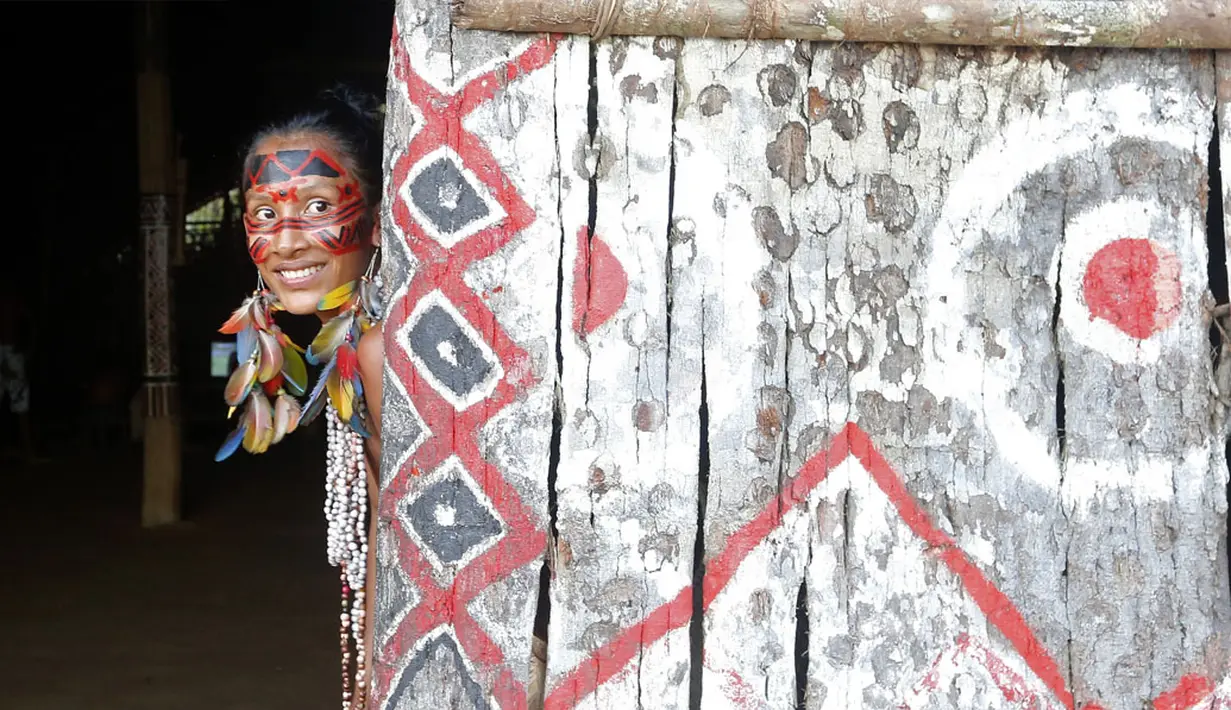 Seorang anggota suku Amazon Tatuyo tersenyum saat terlihat di desanya, Rio Negro (Black River) dekat Manaus City, Brasil, (23/6/2014). (REUTERS/Andres Stapff)
