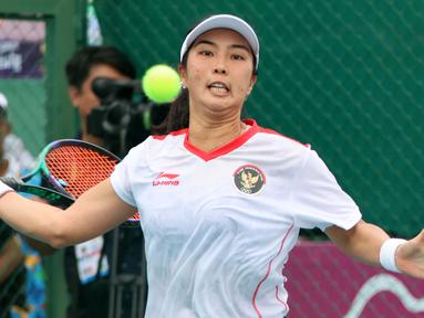 Petenis putri Indonesia, Aldila Sutjiadi berusaha mengembalikan bola ke arah petenis Thailand, Aunchisa Chanta pada pertandingan final tenis beregu putri SEA Games 2023 di Tennis Arena, Morodoc Techo National Stadium, Phnom Penh, Kamboja, Selasa (9/5/2023). Indonesia sempat tertinggal di partai pertama namun sukses menyamakan kedudukan saat partai kedua. Pasangan Aldila dan Jessy kemudian sukses menyegel kemenangan partai ketiga sekaligus memberikan emas ke-24 untuk Indonesia. (Bola.com/Abdul Aziz)