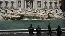 Para aktivis memanjat ke dalam air mancur terkenal itu dan menuangkan cairan karbon berbasis sayuran ke dalamnya, sebelum akhirnya ditarik keluar dan dikawal oleh polisi. (Handout / LAST GENERATION / AFP)