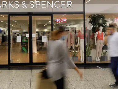 Orang-orang berjalan melewati cabang Marks and Spencer di London, Selasa (18/8/2020). Peretail Inggris, Marks & Spencer pada Selasa (18/8) mengumumkan rencananya untuk memangkas 7.000 pekerja dalam tiga bulan ke depan di tengah pandemi COVID-19. (AP Photo/Kirsty Wigglesworth)