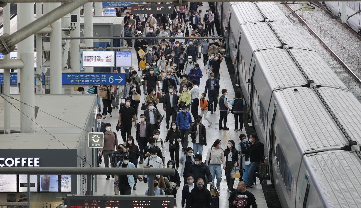 Penumpang memakai masker untuk membantu melindungi dari penyebaran virus corona keluar dari kereta menjelang liburan Chuseok atau Hari Thanksgiving versi Korea di Stasiun Kereta Seoul di Seoul, Korea Selatan, Selasa (29/9/2020). (AP Photo / Ahn Young-joon)
