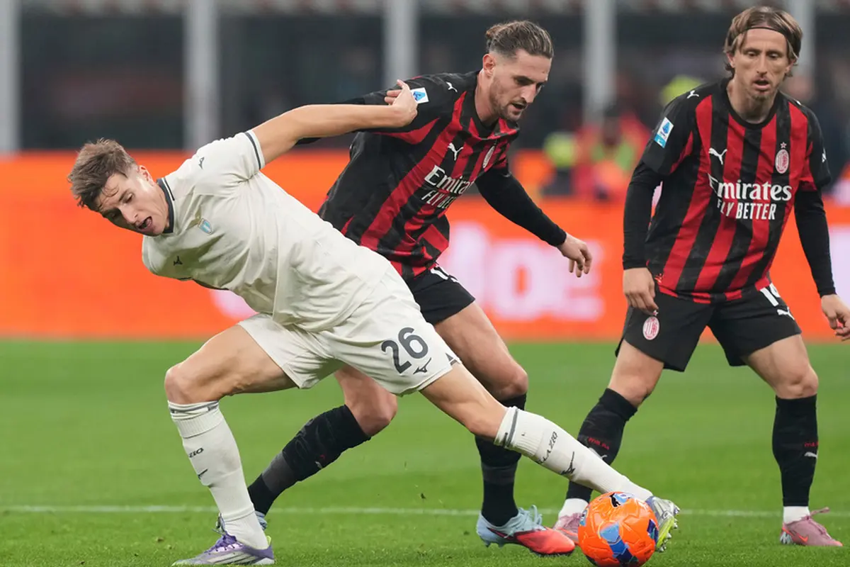 Luka Modric dari AC Milan melihat rekan setimnya, Adrien Rabiot, berebut bola dengan pemain Lazio, Toma Basic