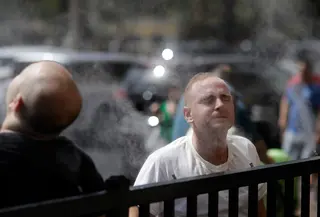 Warga mendinginkan diri dengan kabut air di sepanjang Las Vegas Strip, Amerika Serikat, Selasa (24/7). Badan Cuaca Nasional telah mengeluarkan peringatan panas ekstrem untuk lembah Las Vegas. (AP Photo/John Locher)