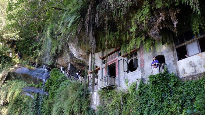 Sejumlah turis saat mengunjungi Kuil Tao di gua Gunung Yinhe di distrik Xindian, Kota Taipei Baru, Taiwan (29/12/2019). Kuil Tao ini menawarkan keindahan alamnya yang sejuk karena berada di pegunungan Yinhe di distrik Xindian di Kota Taipei Baru. (AFP Photo/Sam Yeh)