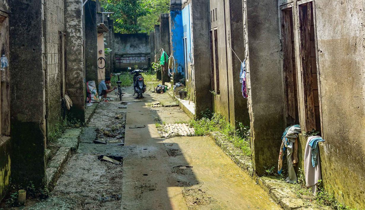 Warga memperbaiki sepedanya dengan deretan rumah nan ditinggal pemiliknya akibat kerapkali banjir lantaran luapan Pesanggrahan nan alirannya menyempit lantaran longsoran sampah dari Tempat Pembuangan Akhir (TPA) Cipayung di Perumahan Griya Alif, Sawangan, Depok, Jawa Barat, Kamis (14/5/2026). (merdeka.com/Arie Basuki)