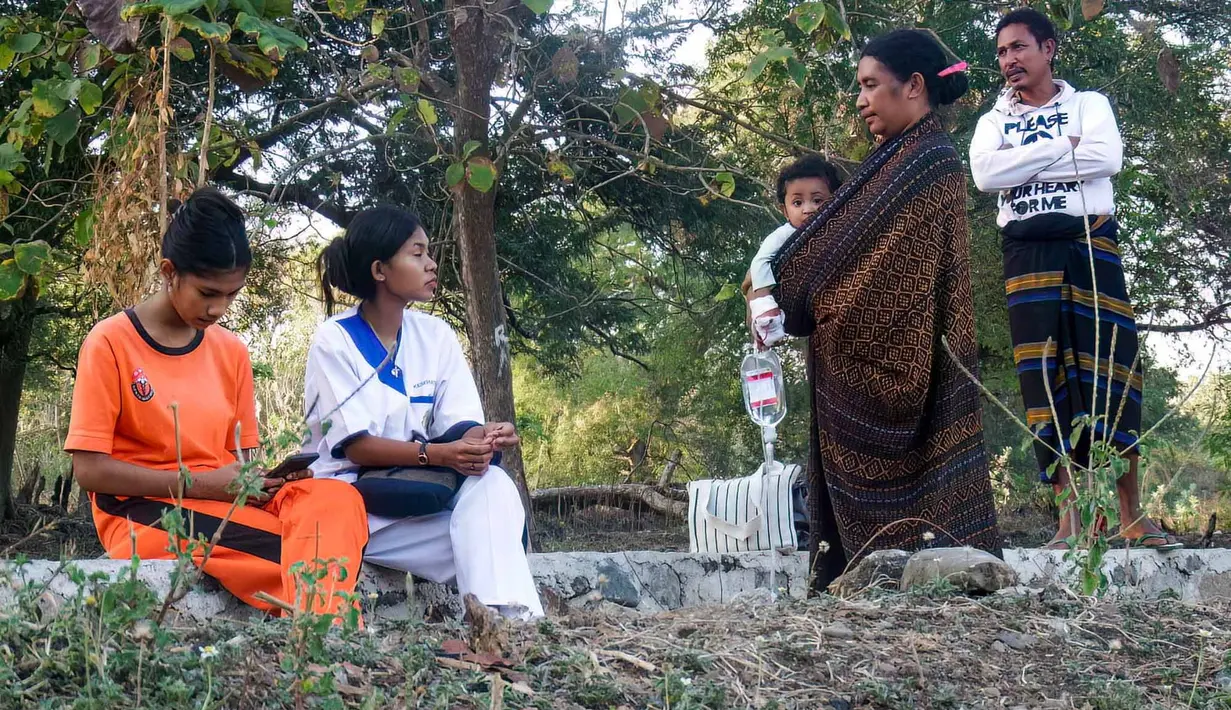 Pasien dan petugas medis menunggu setelah dievakuasi dari puskesmas Watubaing akibat gempa bumi di Desa Watubaing, Sikka, Nusa Tenggara Timur, Sabtu, 15 Agustus 2026. (AFP/ Arnold Welianto)