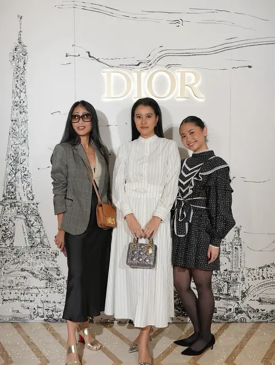 Ia mengenakan stripe shirt dress berwarna putih yang simple dengan aksen stripe obi. [@marcella.zalianty]