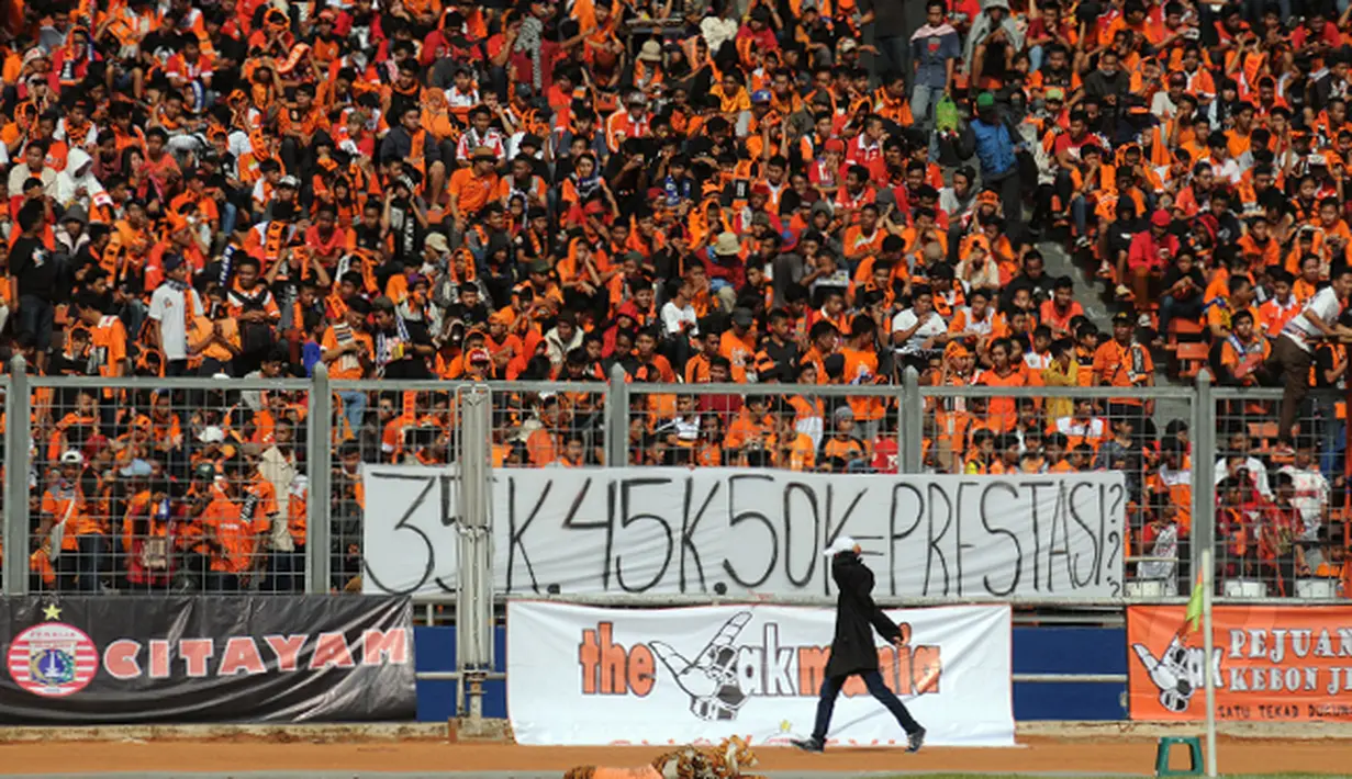 Suporter Persija membentangkan spanduk protes kenaikan harga tiket dibandingkan dengan prestasi tim Macan Kemayoran saat laga Persija melawan Persela di Stadion GBK Jakarta, Minggu (1/3/2015). (Liputan6.com/Helmi Fithriansyah)