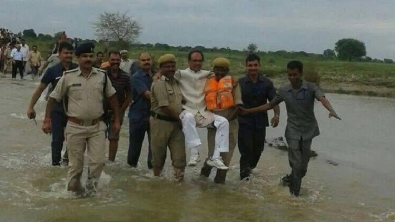 Menteri dari negara Madhya Pradesh, Shivrah Singh Chauhan tertangkap kamera tengah dibopong dalam kunjungannya ke daerah yang dilanda banjir