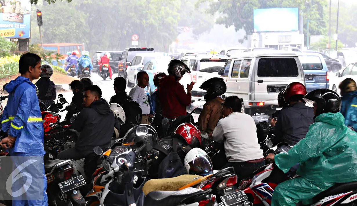 Pengendara sepeda motor berteduh di bawah flyover saat hujan turun, Jakarta, Senin (16/11). Petugas kepolisian akan menerapkan tilang dengan denda maksimal Rp250.000. (Liputan6.com/Immanuel Antonius)