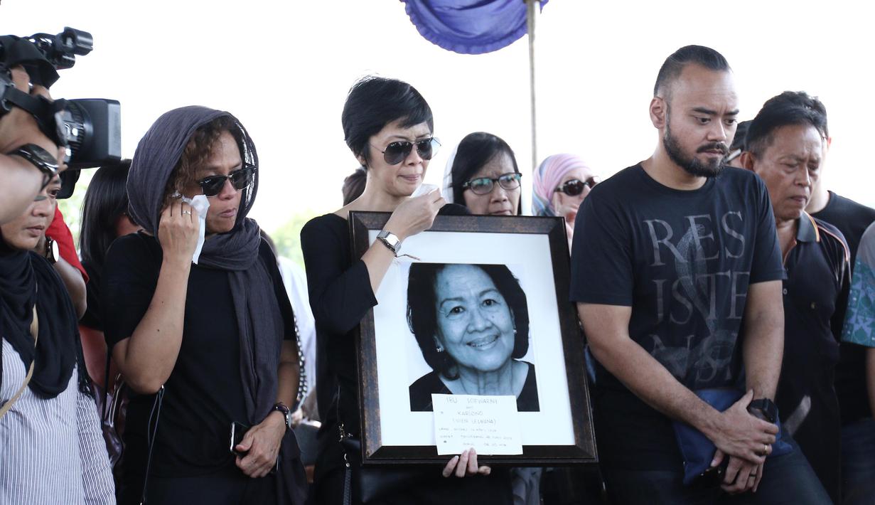 Ekspresi kesedihan Mira Lesmana saat pemakaman ibunya, Nien Lesmana di TPU Tanah Kusir, Jakarta, Rabu (28/6). Ibu dari Indra Lesmana dan Mira Lesmana meninggal dunia pada usai 88 tahun. (Liputan6.com/Herman Zakharia)