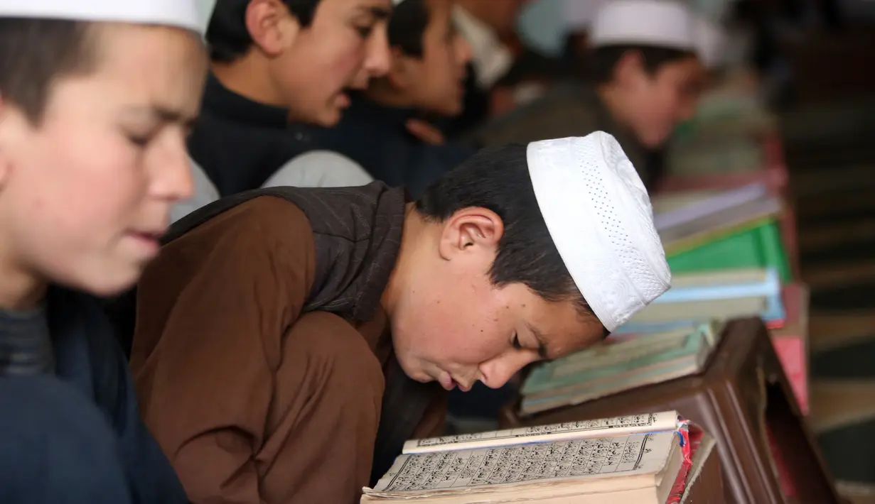 Ekspresi anak-anak saat belajar membaca Alquran di sebuah masjid di Kabul, Afghanistan, Senin, (21/5). Anak-anak Afghanistan lebih memperdalam Alquran di saat Ramadan. (AP Photo/Rahmat Gul)