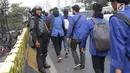 Personel Brimob memberikan senyum kepada rombongan mahasiswa yang akan kembali usai berunjuk rasa di sekitar Jembatan Layang Gerbang Pemuda, Jakarta, Selasa (1/10/2019). Mahasiswa dari berbagai perguruan tinggi kembali berunjuk rasa menolak beberapa RUU. (Liputan6.com/Helmi Fithriansyah)