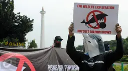 Aktivis JAAN membentangkan tulisan menolak eksploitasi hewan lumba-lumba di Jakarta, Senin (31/10). Mereka menilai pentas satwa lumba-lumba tidak menyampaikan pesan edukasi dan tidak menghargai . (Liputan6.com/Helmi Fithriansyah)