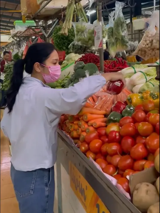 Dari video singkat yang dibagikan, pemeran Kinara dalam film Dancing in the Rain itu mengenakan celana panjang jeans warna biru. Mengenakan kemeja panjang dan masker warna pink. [Instagram/bungazainal05]