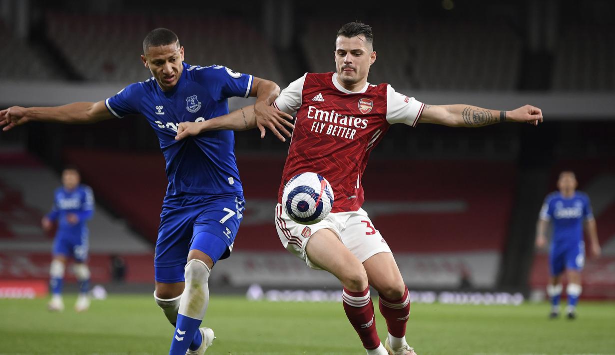 Striker Everton, Richarlison (kiri) berebut bola dengan gelandang Arsenal, Granit Xhaka dalam laga lanjutan Liga Inggris 2020/2021 pekan ke-33 di Emirates Stadium, London, Jumat (23/4/2021). Everton menang 1-0 atas Arsenal. (AP/Michael Regan/Pool)