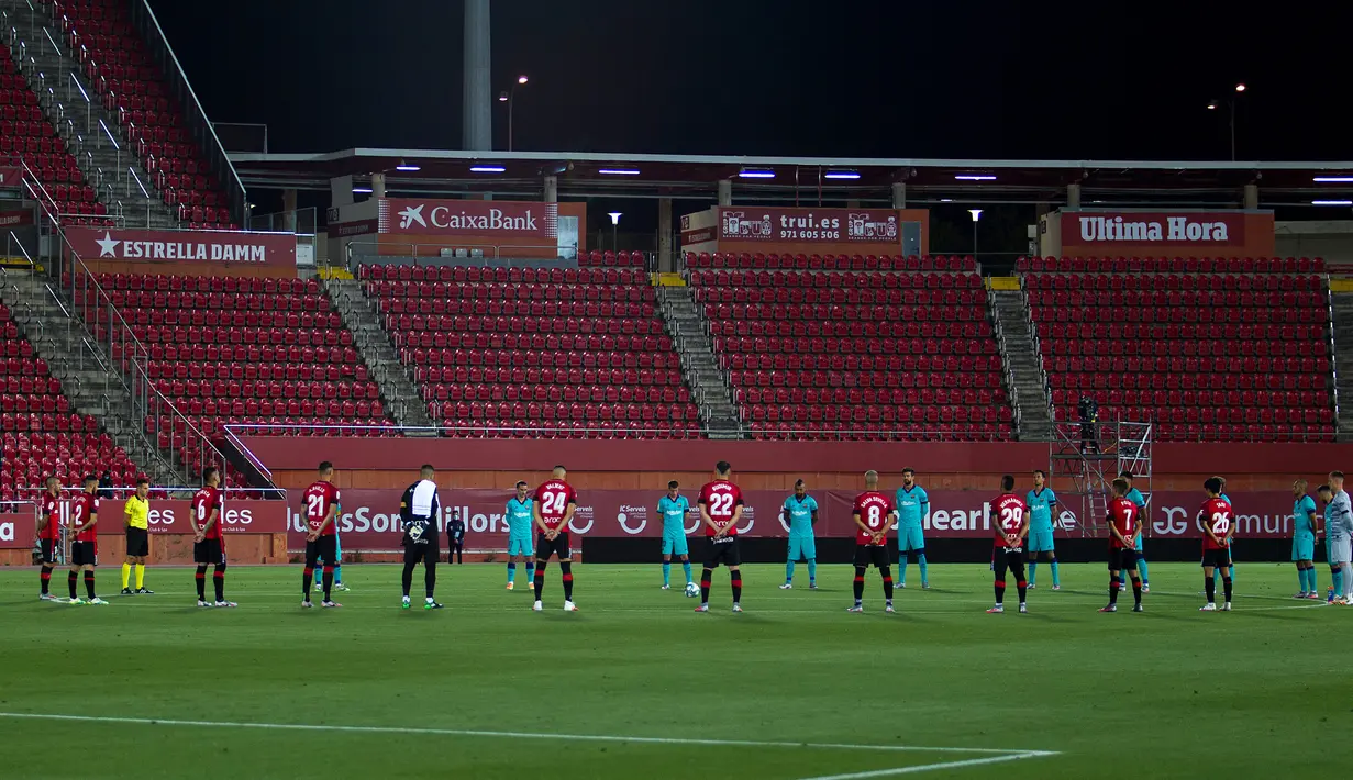Para pemain Barcelona dan Mallorca mengheningkan cipta untuk para korban virus corona COVID-19 sebelum pertandingan La Liga di Son Moix Stadium, Palma de Mallorca, Spanyol, Sabtu (13/6/2020). Barcelona membantai Mallorca dengan skor 4-0. (JAIME REINA/AFP)