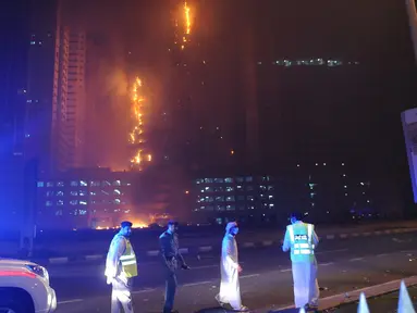 Personel Pertahanan Sipil dikerahkan untuk menangani kebakaran yang melanda gedung apartemen mewah di Ajman, Uni Emirat Arab (UEA), Senin (28/3) malam waktu setempat. Kepolisian memastikan tidak ada korban jiwa dalam insiden tersebut. (REUTERS/Stringer)