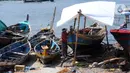 Tukang kayu memperbaiki kapal motor di Pelabuhan Kalibaru, Jakarta, Rabu (8/3/2023). Untuk perbaikan satu unit kapal motor nelayan tradisional membutuhkan biaya sekitar Rp 100 juta. (merdeka.com/Imam Buhori)